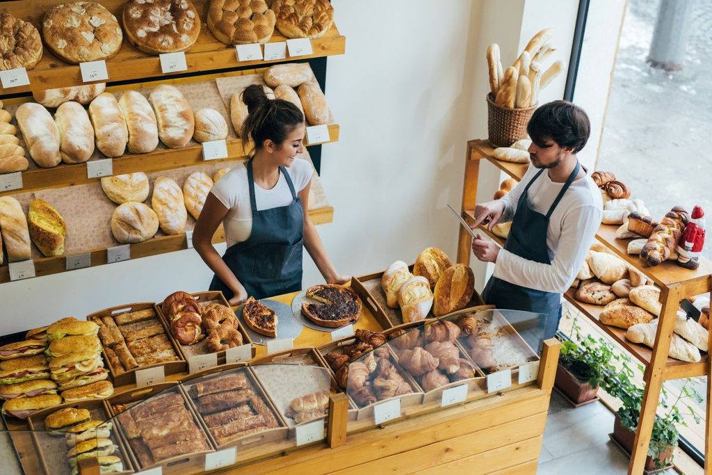 Two employees using a tablet at a bakery